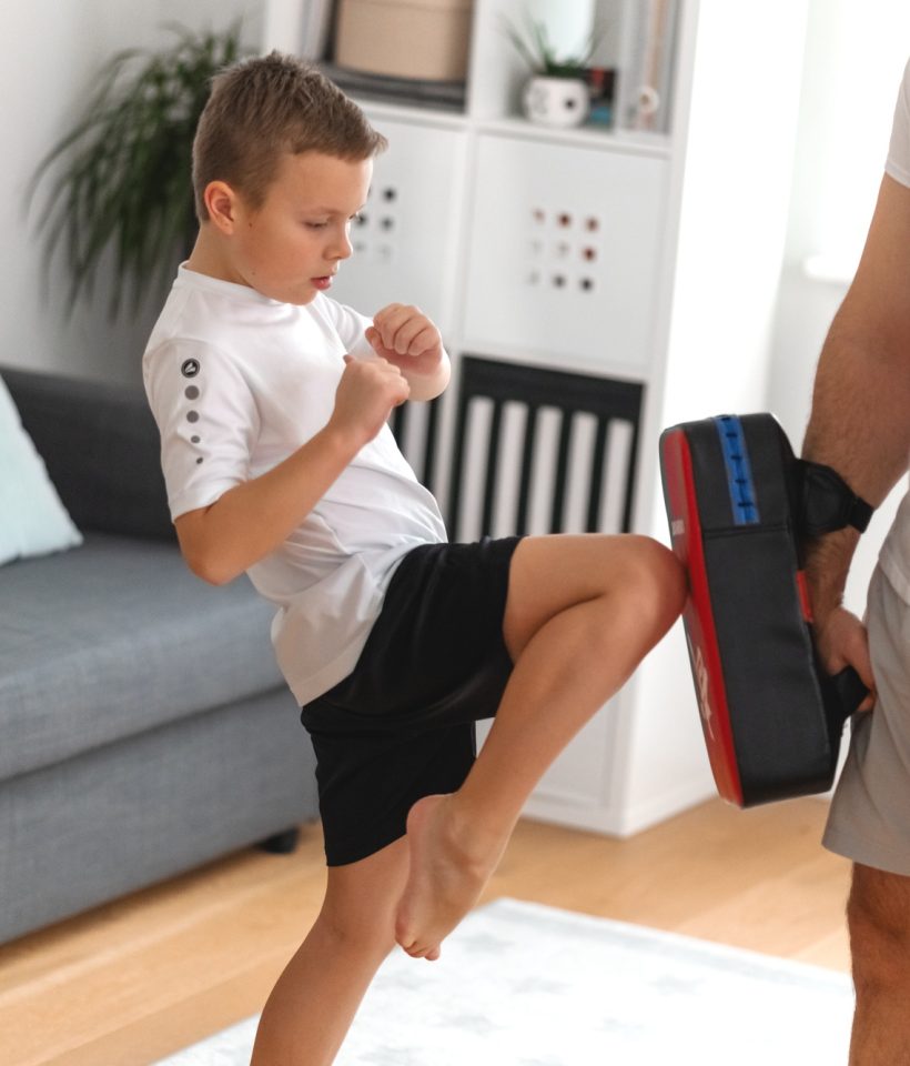 A young boy is training with father, martial arts, taekwondo. Dad and son