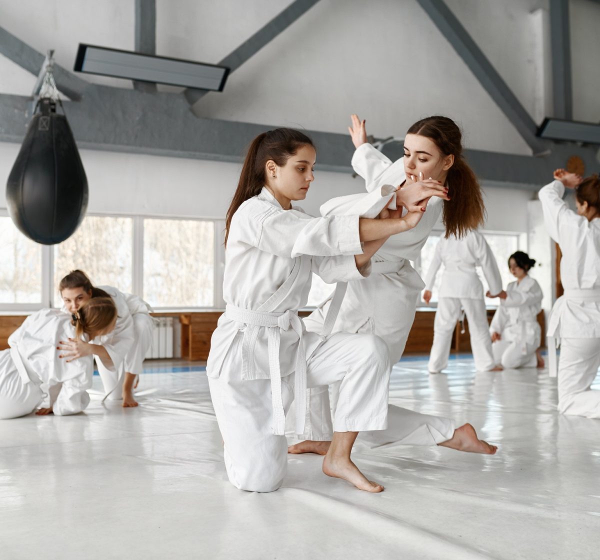 Teenage girls fighting at aikido training in martial arts school